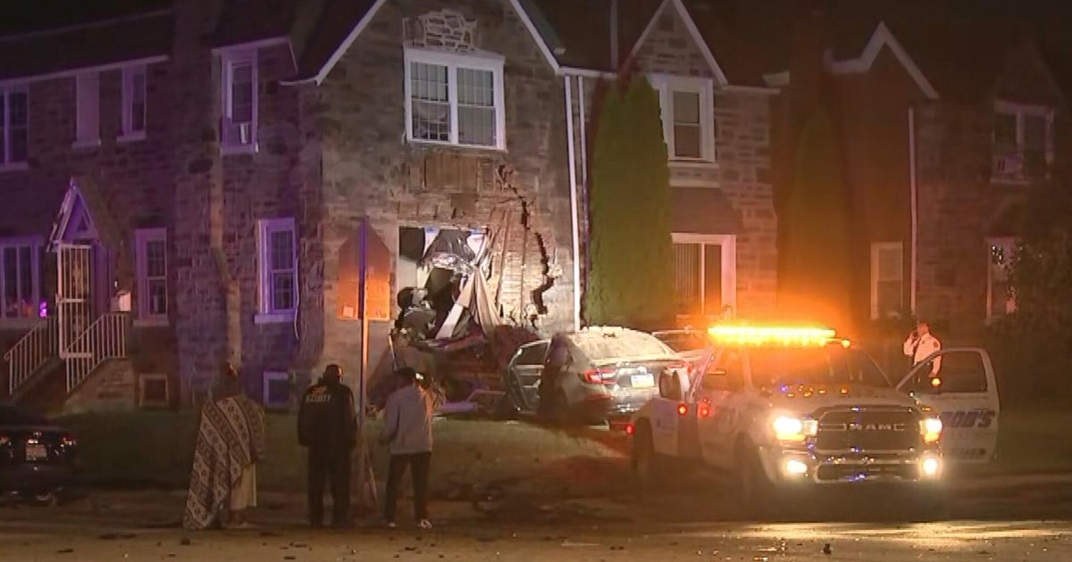 Philadelphia house has car removed from its side after Thursday morning crash.
