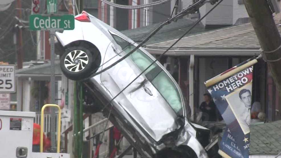 Woman discharged from hospital following accident that left car dangling from wires