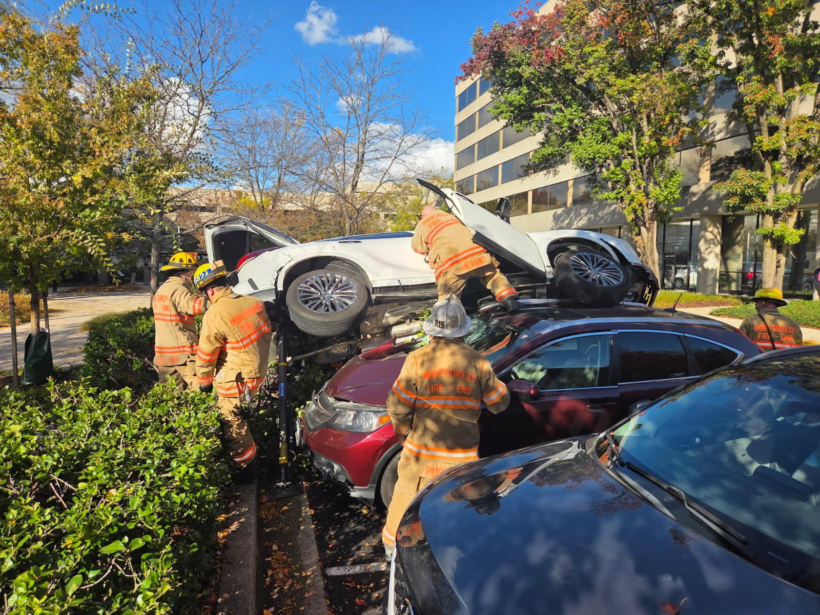 MCFRS: Car accident injures one, lands on top of 2 vehicles in parking lot