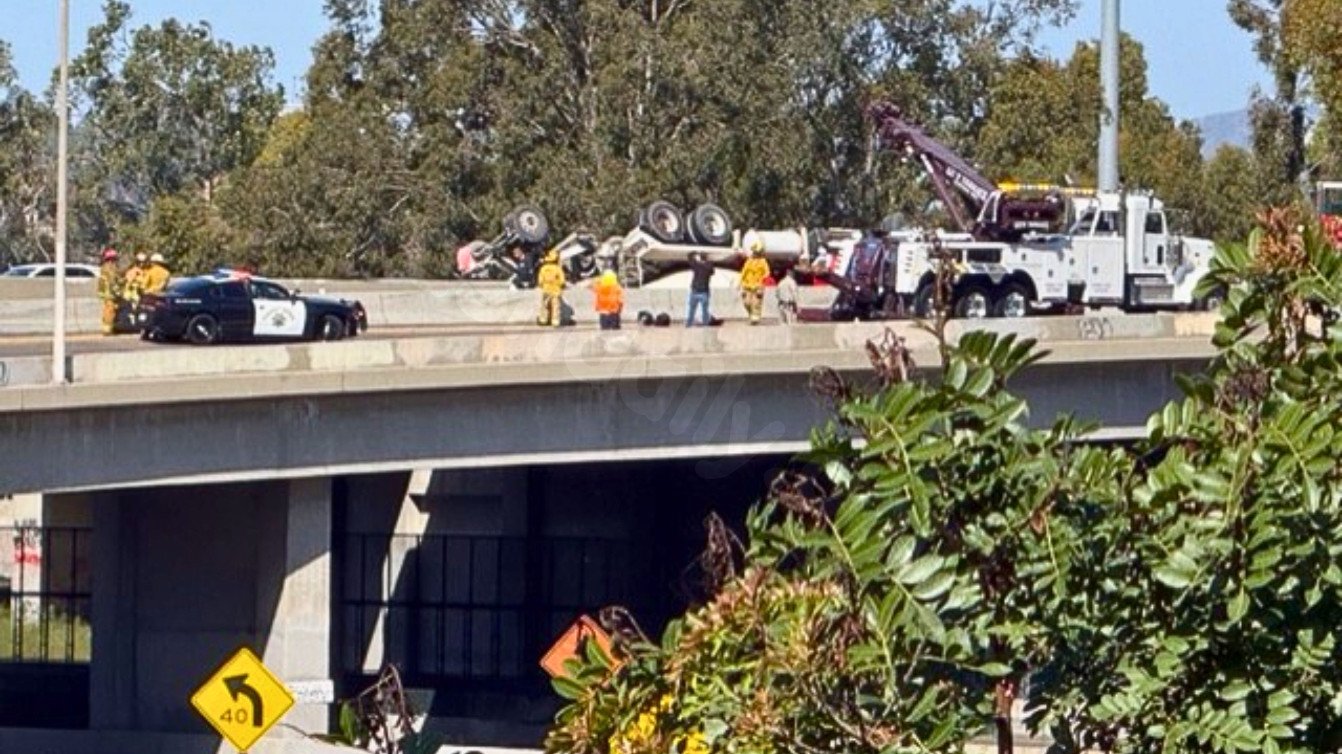 Overturned truck dangling over freeway spills concrete, snarls traffic in Boyle Heights