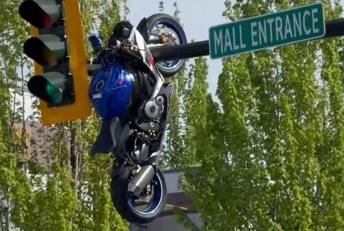 Watch: Motorcycle left dangling from traffic light after crash