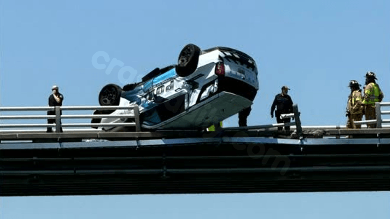 VIDEO: Upside-down police car teeters on edge of bridge after crash